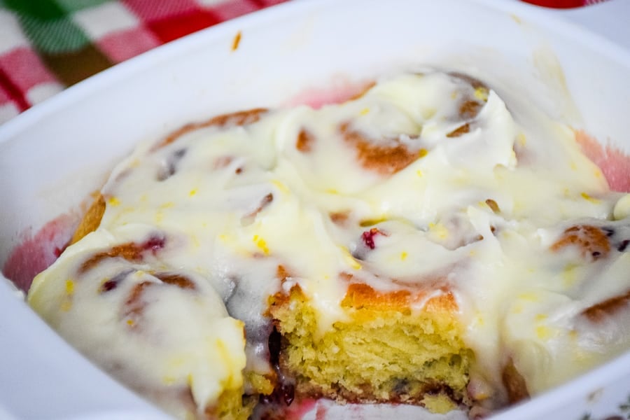 Cranberry Orange Sweet Rolls in dish with one roll cut out.