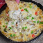 Scooping into the baked Philly Cheesesteak Dip