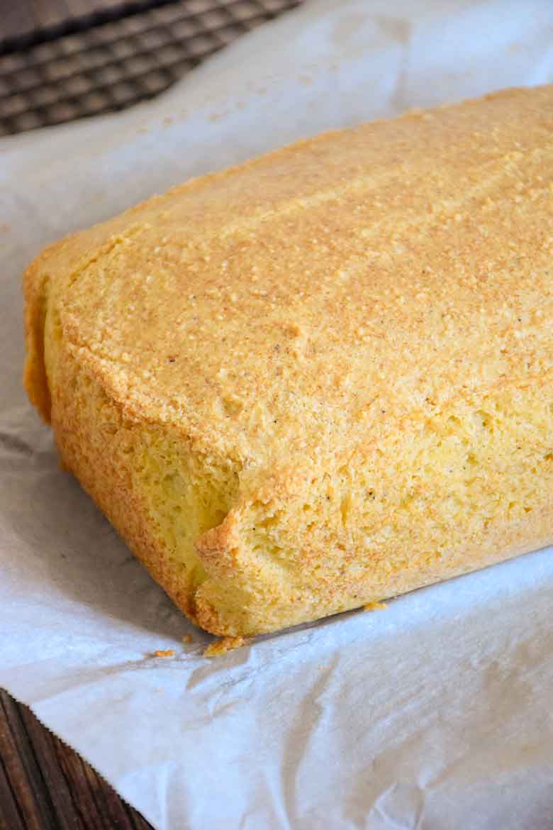 A grain free Baked loaf of Keto Bread before cutting into slices sitting on parchment paper.