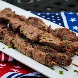 Skewers of cooked beef riblets on a serving plate