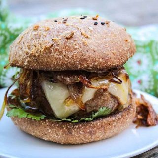 Barbecue Sauce glazed Chipotle Burger topped with cheese and crispy shallots with fresh cilantro on a keto burger bun