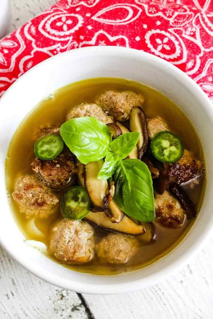 Pho Soup with Veal Meatballs in a white bowl with red and white napkin