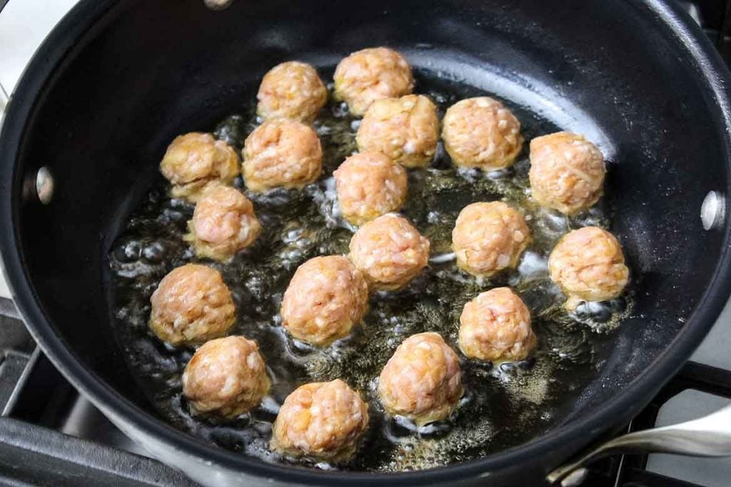 mini veal meatballs cooking in the skillet