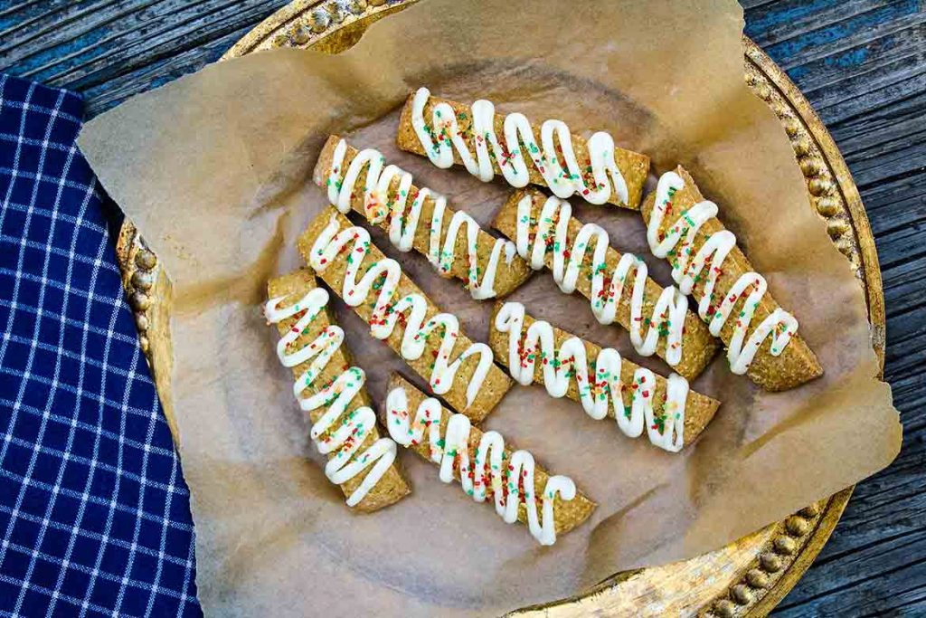 Pumpkin Biscotti drizzled with vanilla glaze on parchment lined serving tray