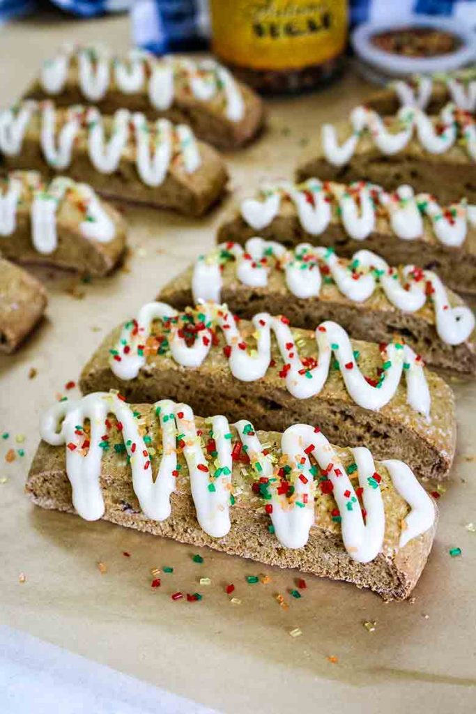 Pumpkin Biscotti with icing drizzle and fall colored sugars on parchment paper