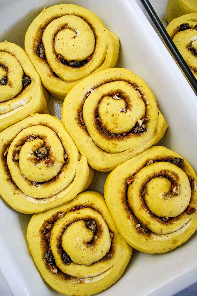 Cut pumpkin spice cinnamon roll dough in the baking dish.