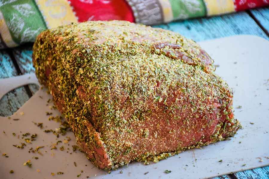 Uncooked roast with dry rub on a cutting board.