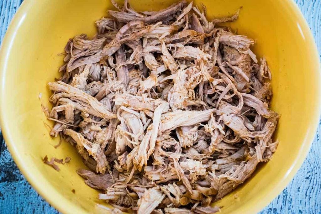 cooked keto pulled pork in a blue serving bowl