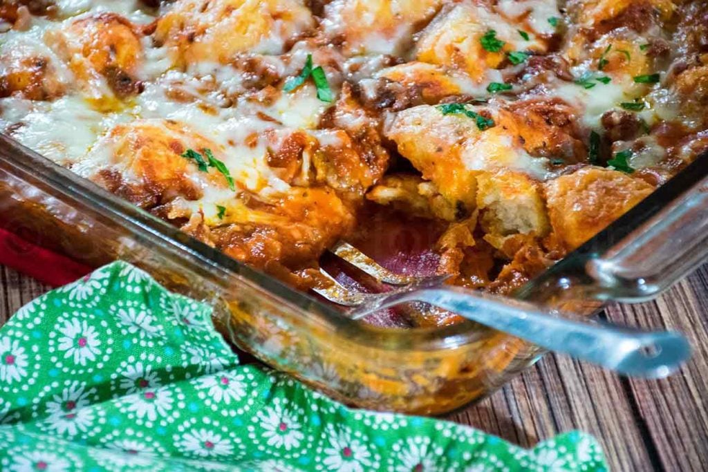 bubble up pizza casserole with a serving removed and the serving spatula in the dish