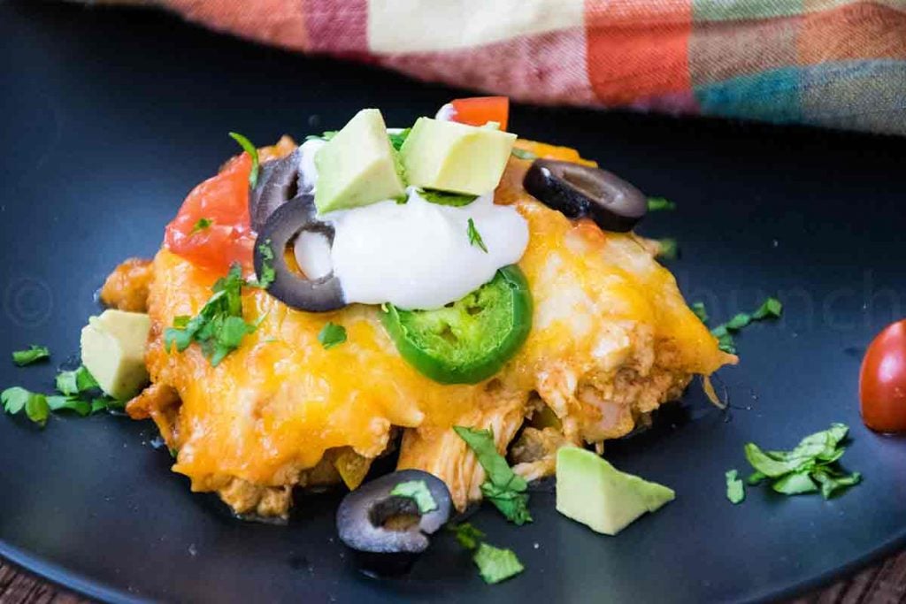 A serving of Chicken Enchilada Casserole on a black plate