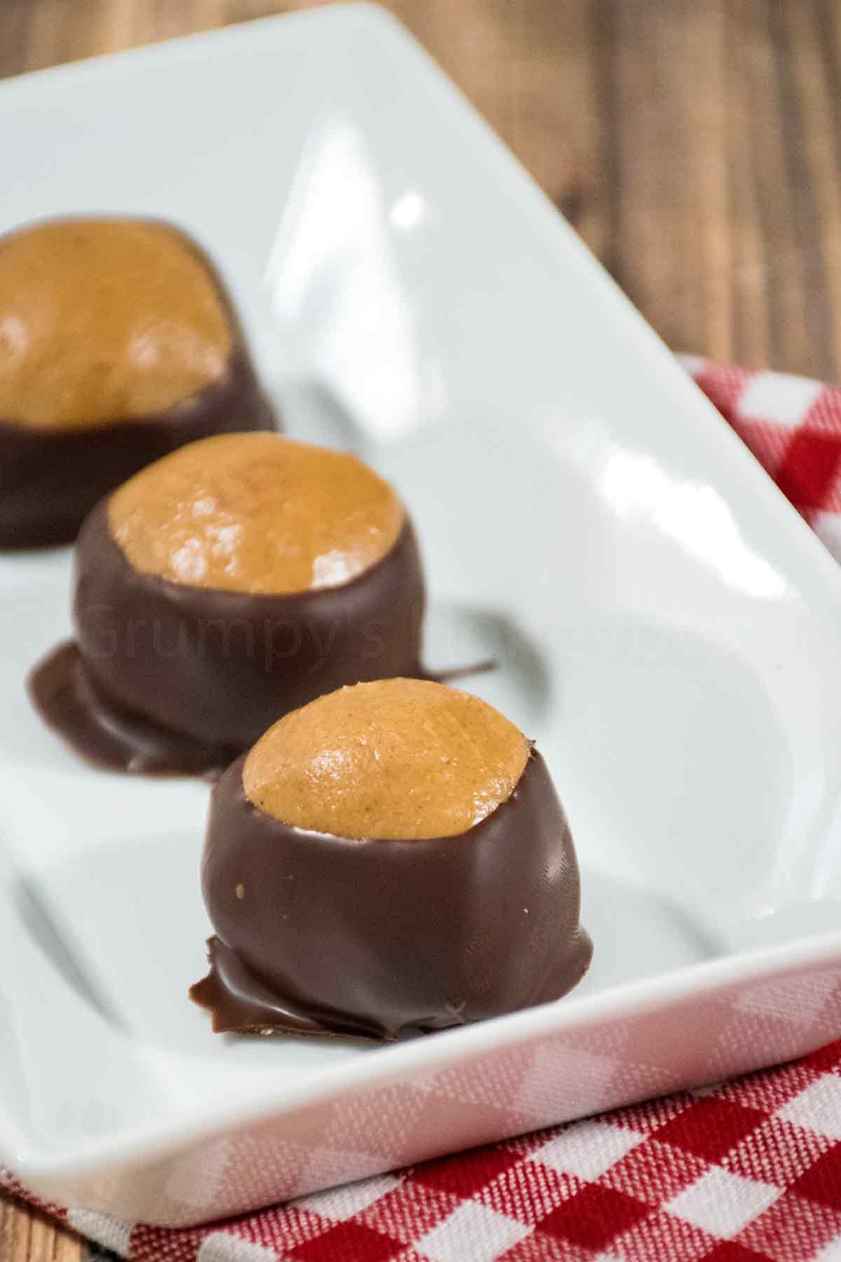 Three keto buckeyes on a white plate.