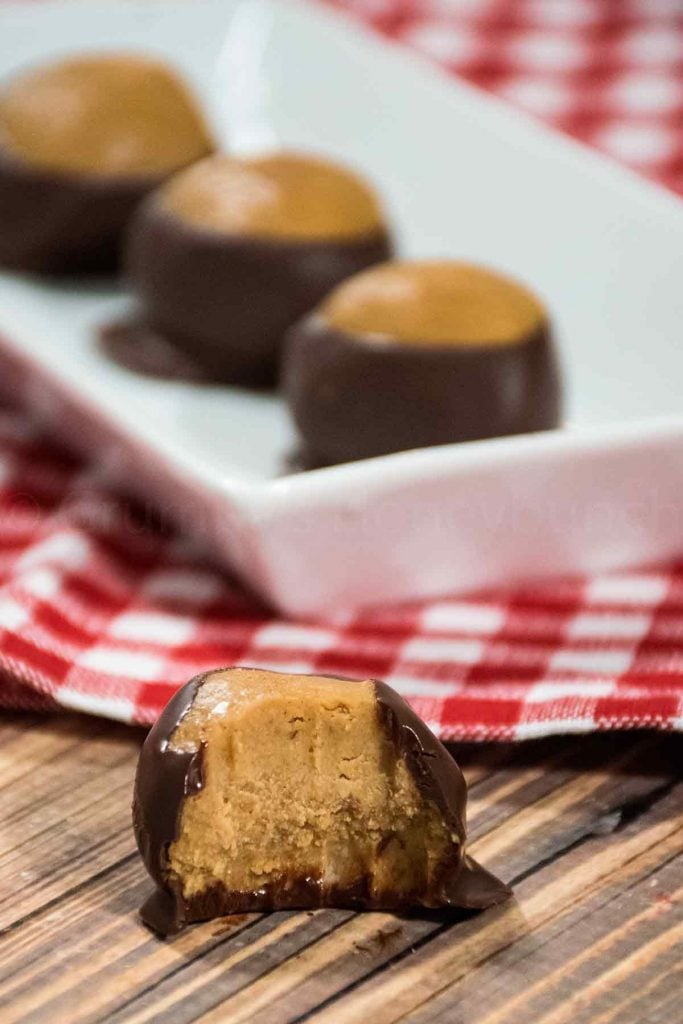 Keto Buckeye with a bite taken from it with more buckeyes in the background