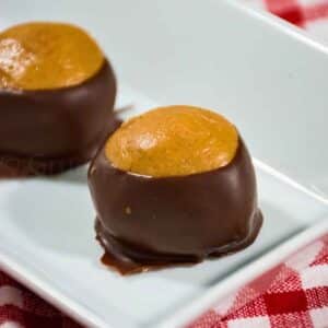 A plate of homemade peanut butter buckeye candy with a classic chocolate coating.