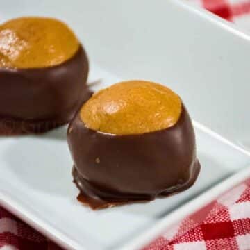 A plate of homemade peanut butter buckeye candy with a classic chocolate coating.