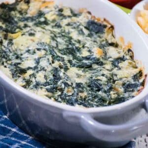 Baked hot spinach artichoke dip in a light gray casserole dish.