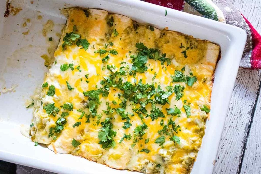 Casserole dish with two enchiladas removed.