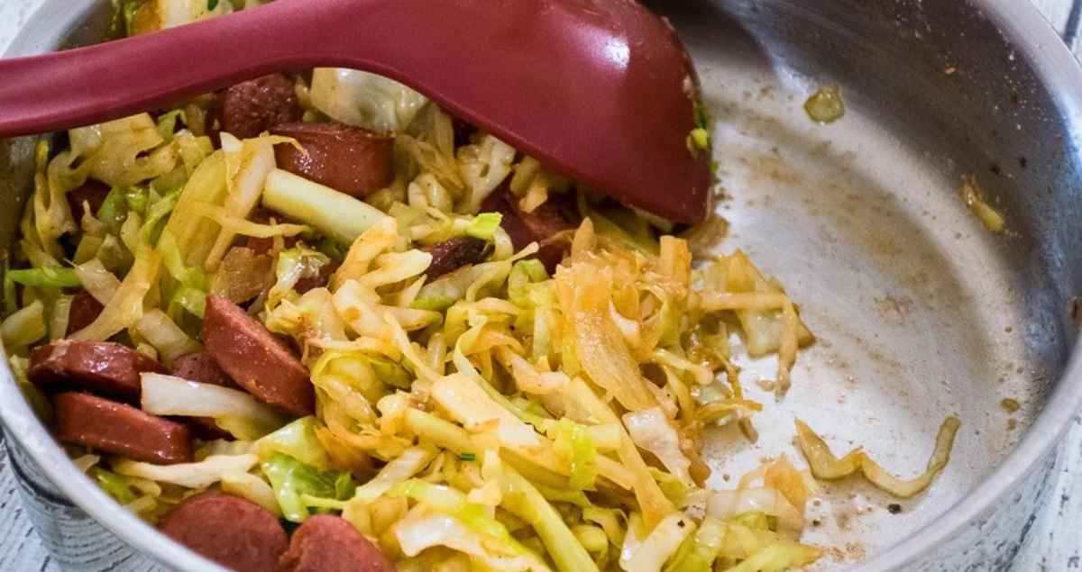 Red serving spoon in a half-served skillet.