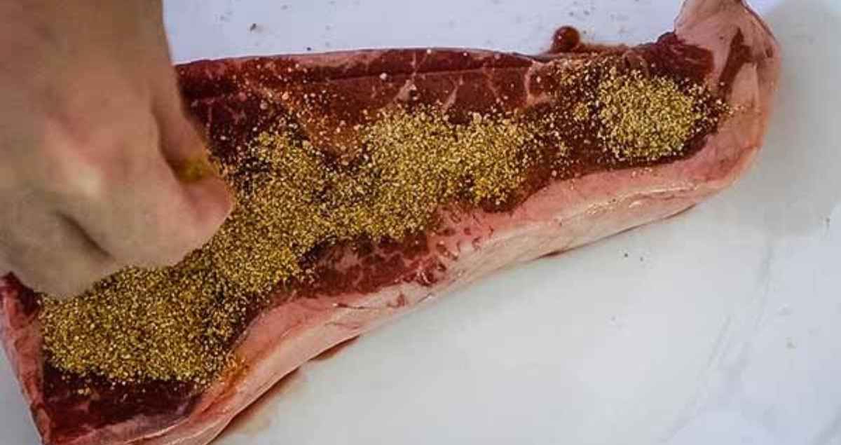 A hand sprinkling the spice blend on a strip steak.