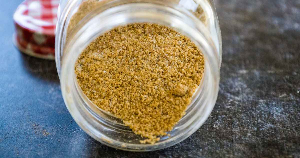 ry Steak Rub in a Jar lying on its side with some of the rub falling down near the top of the jar.