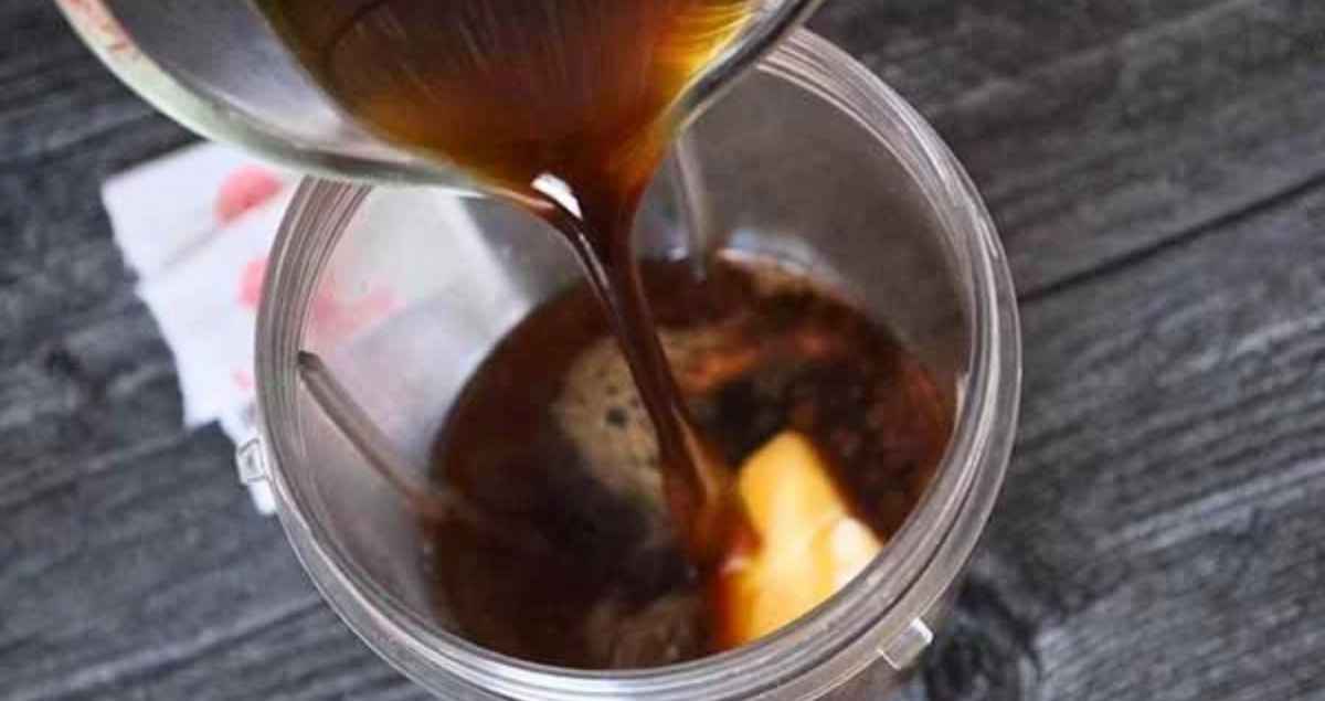 Pouring hot coffee into the blender cup over top of the butter and sweetener.