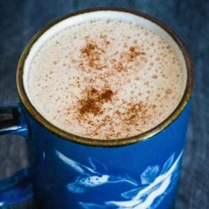 A frothy cup of keto snickerdoodle coffee in a blue mug.