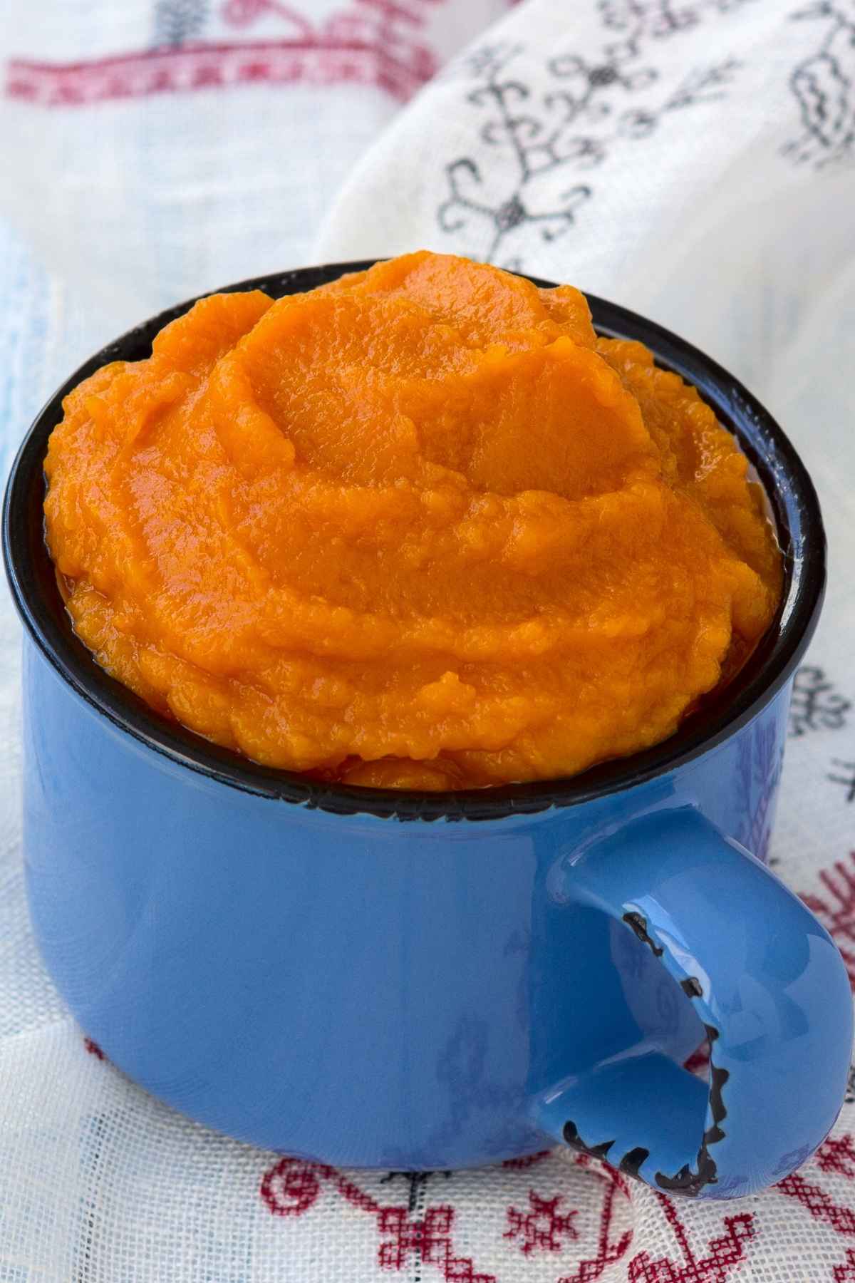 A blue cup filled with pumpkin puree.