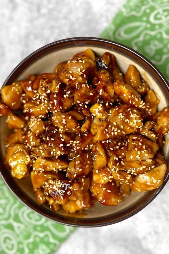 Keto Sesame Chicken sprinkled with sesame seeds in a bowl.