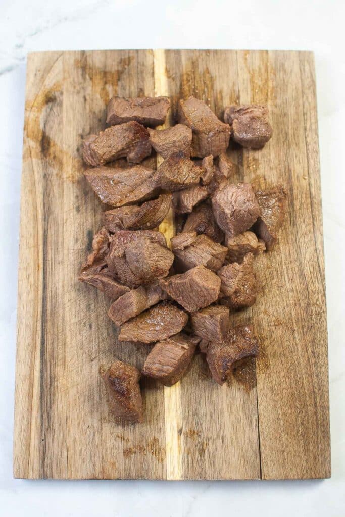 Cooked beef on a cutting board.