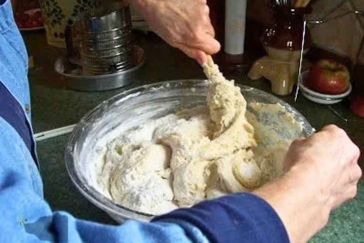 Hand mixing the remaining flour into dough.