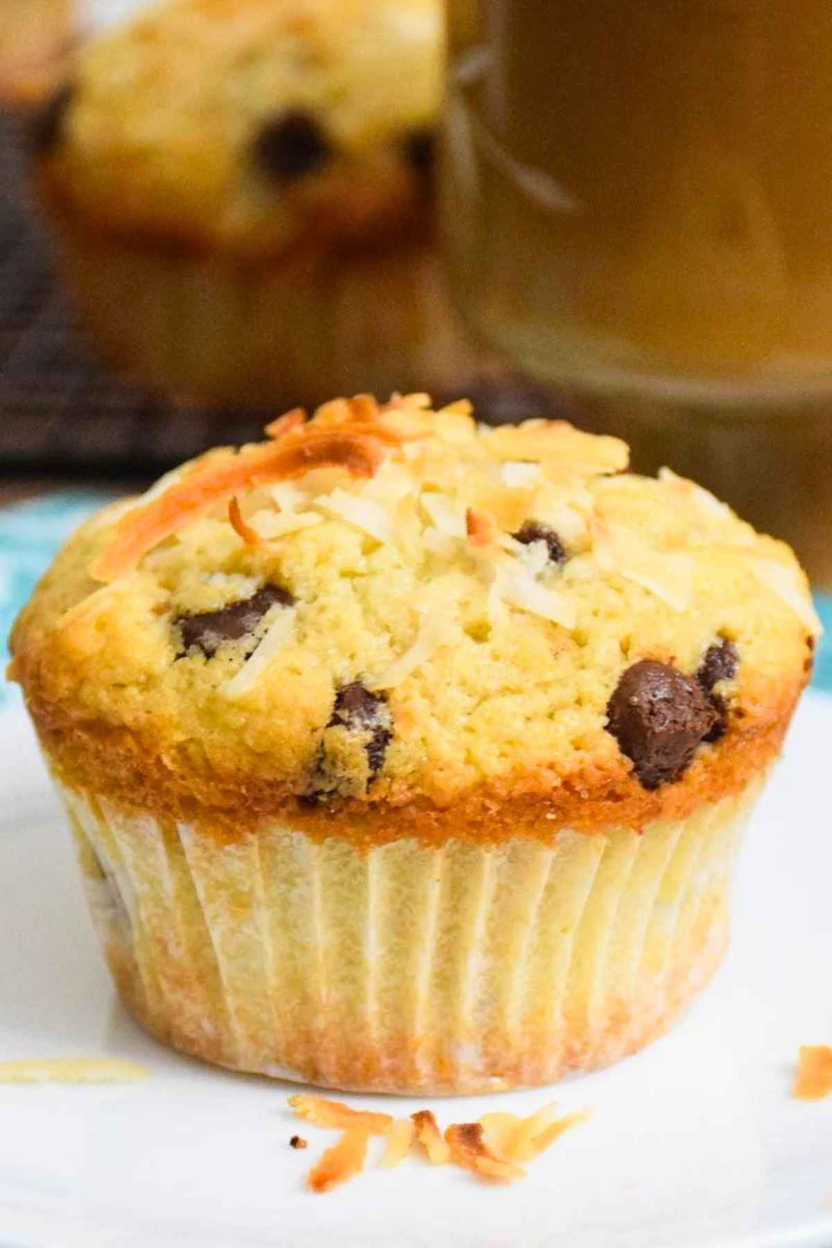Baked coconut chocolate chip muffins on a plate.
