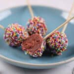 Featured image of Red Velvet Cake Pops on a bllue plate.