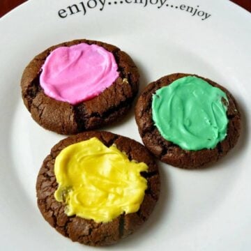 Three Chocolate Mint Cream Cookies on a white plate.