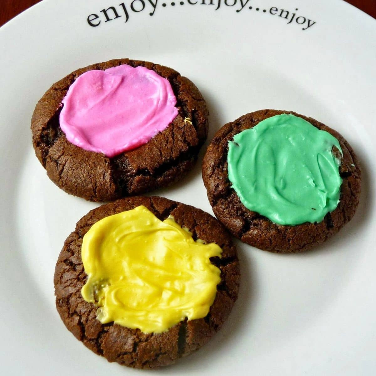 Three Chocolate Mint Cream Cookies on a white plate.
