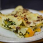 Upclose image of Butternut Squash Kale Lasagna on a cream plate with gold rings.
