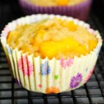 Mango Cardamom Muffin in a yellow floral paper wrapper.