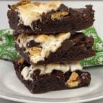 A stack of three S'more Brownies on a white plate.