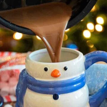 Sugar Free Creamy Hot Cocoa being poured into s snowman mug.