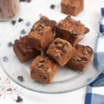 A plate stacked with squares of chocolate marshmallows dotted with chocolate chips.