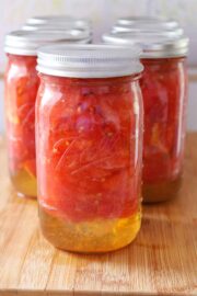 A beautiful display of freshly canned tomatoes in glass jars using the hot water bath method.