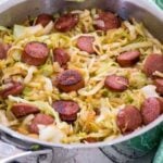 Cooked cabbage and kielbasa in a large skillet.
