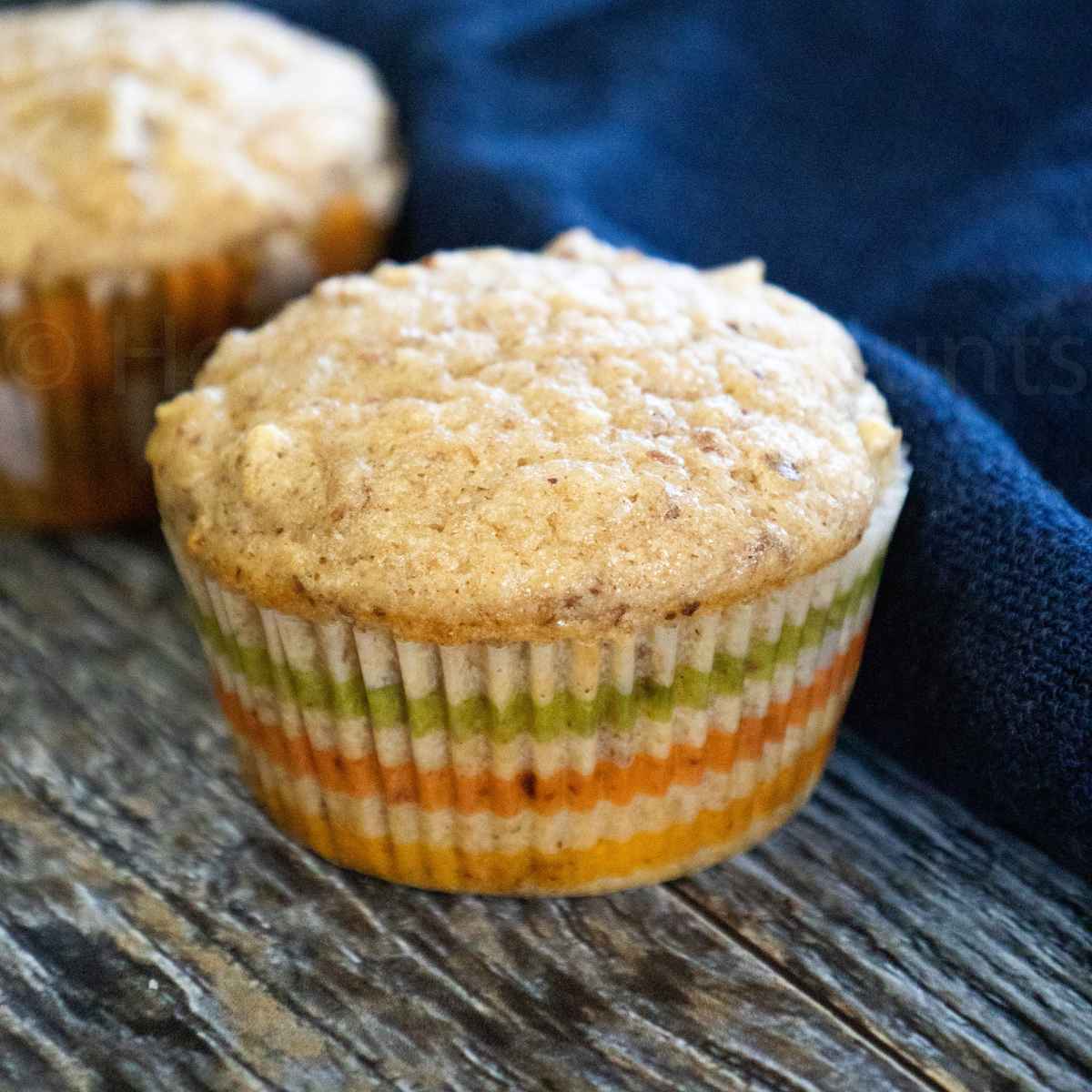 Close-up of an Applesauce Muffing in a green and orange striped paper liner.