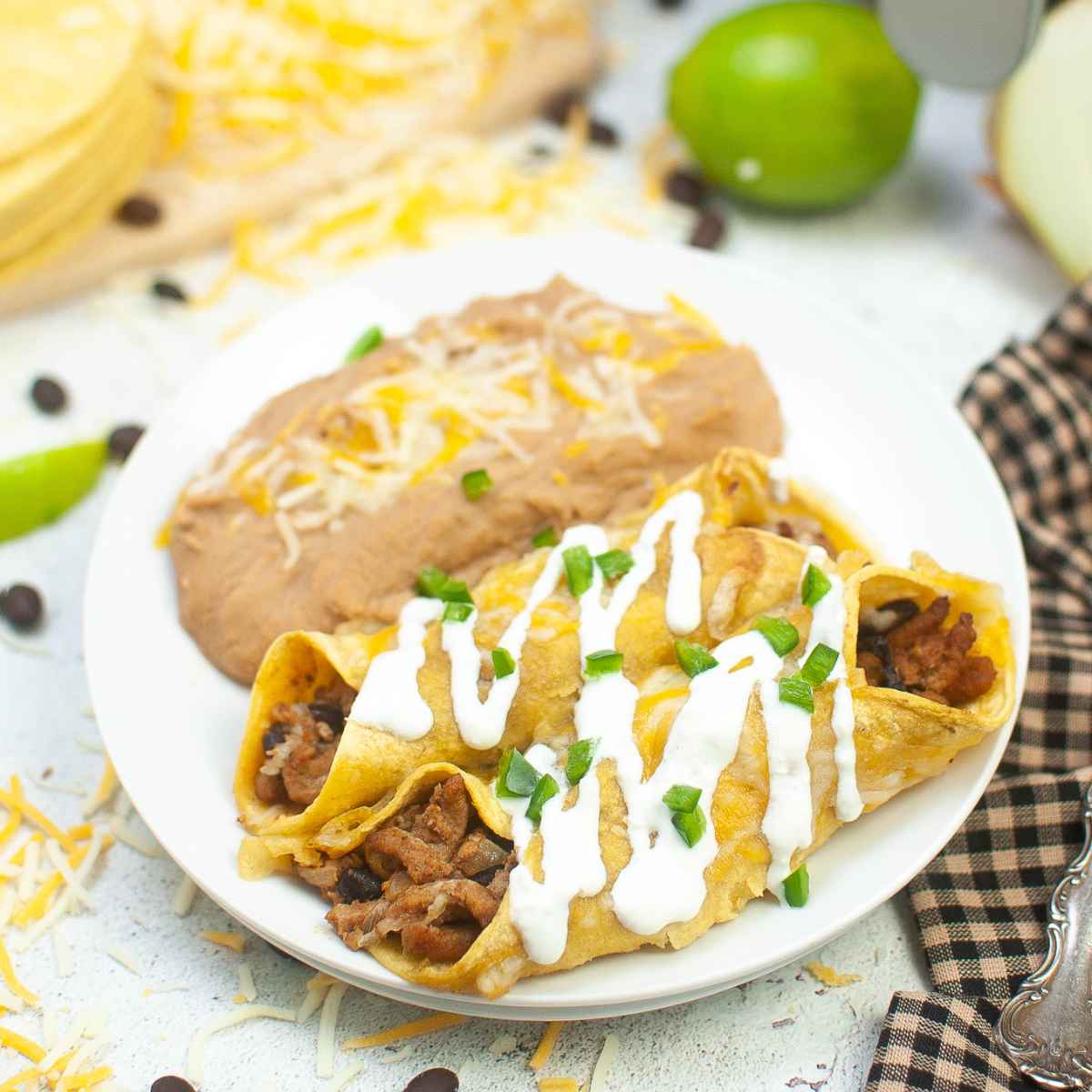 Overhead view of turkey enchiladas with visible filling and refried beans in the background.