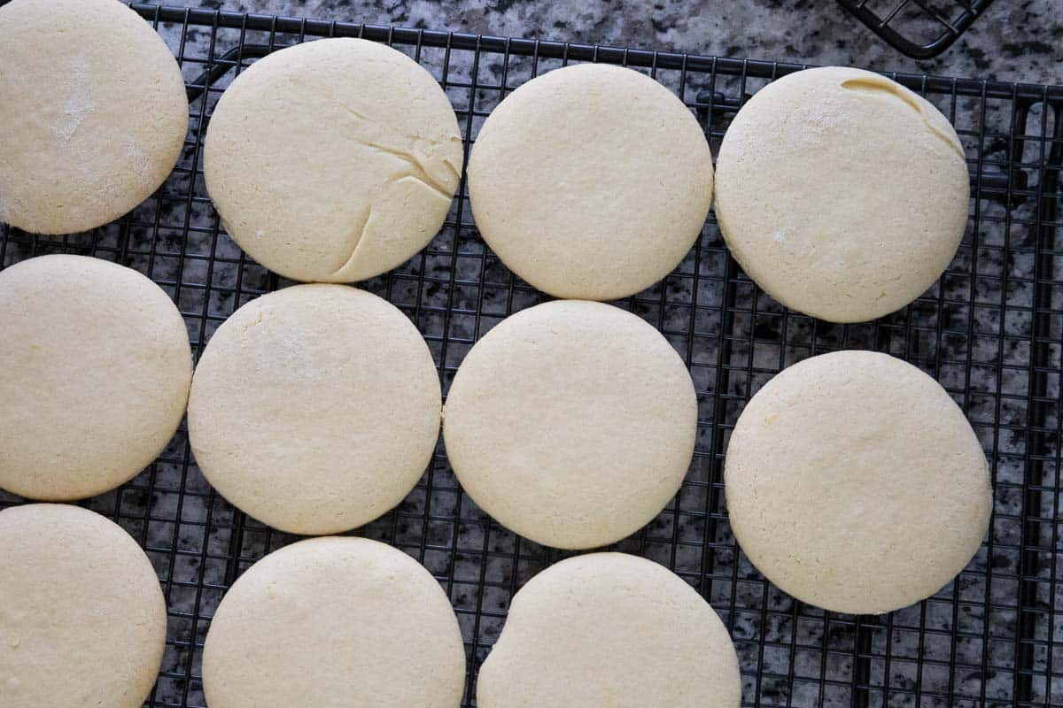 Unglazed cookies cooling on a black wire rack, overhead view on a granite countertop.