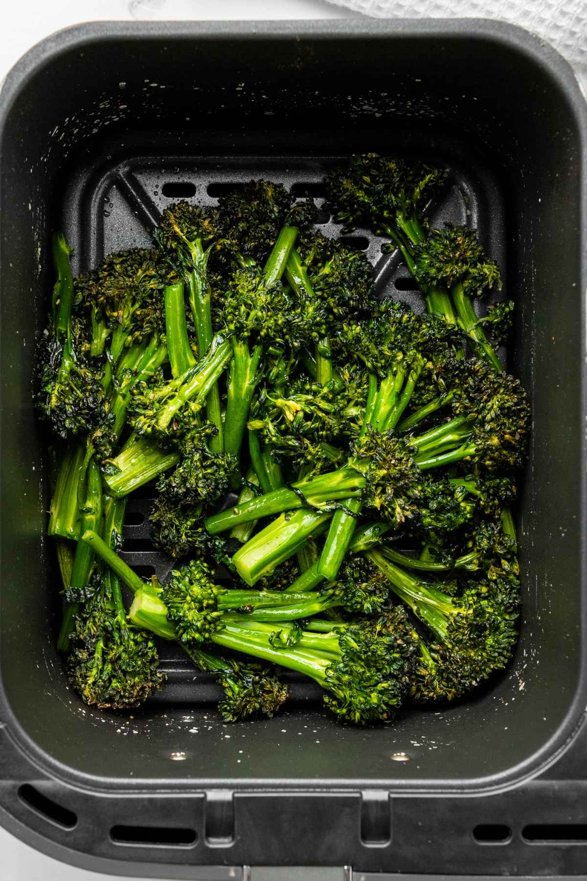 Air Fryer Broccolini cooked in air fryer basket.