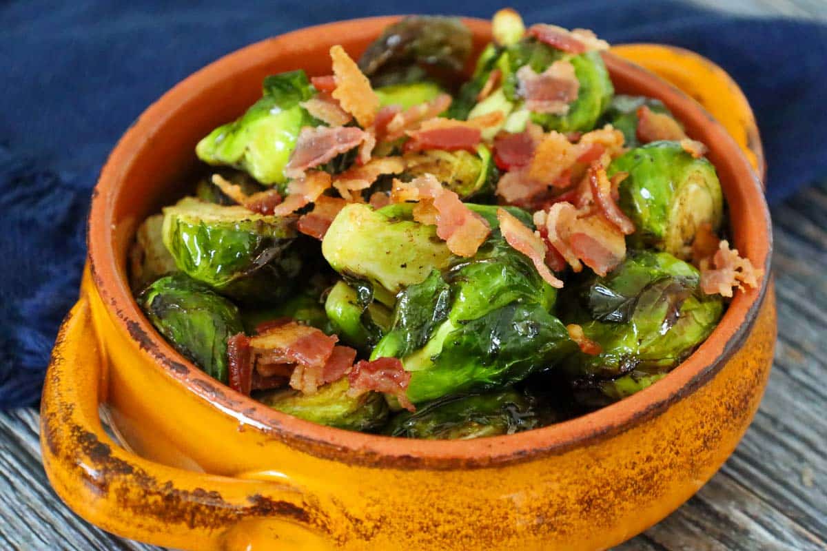 Crispy air fryer brussels sprouts topped with bacon pieces and tossed in a browned balsamic butter.