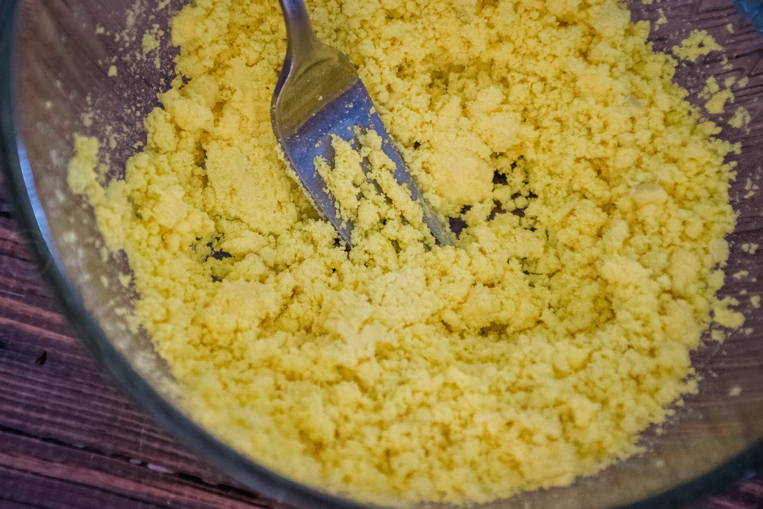 Bowl of mashed egg yolks with a fork.
