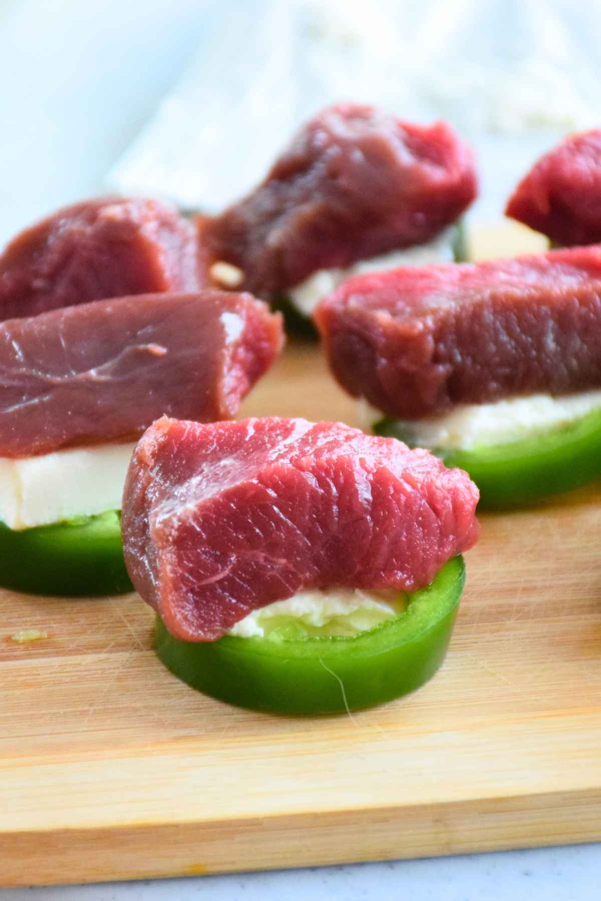 Raw venison tenderloin pieces on jalapeno slices with cream cheese.