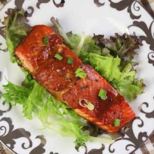 Overhead view of miso maple salmon served on mixed greens and garnished with scallions.