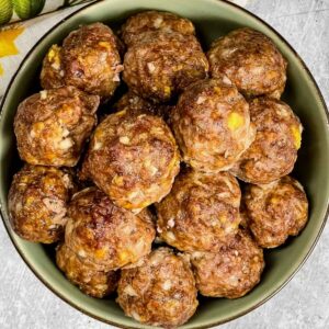 Bowl of juicy oven baked meatballs with onions and cheese, ready to serve as a main dish or appetizer.