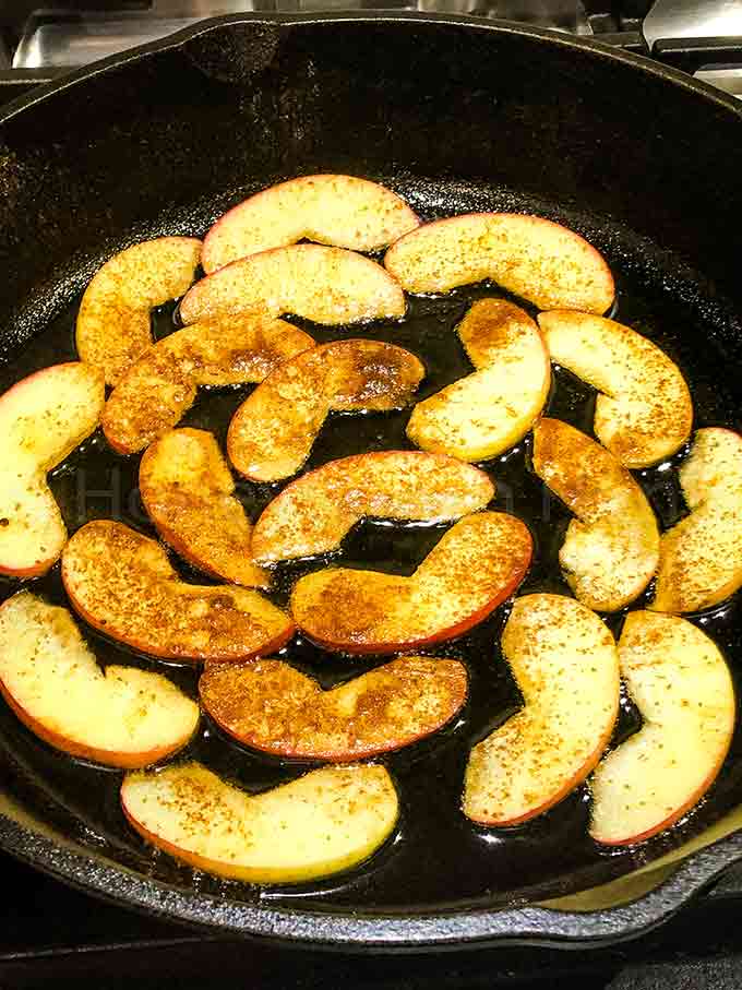 Sliced apples in a cast iron skillet with butter and cinnamon.